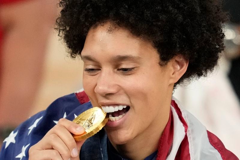 United States' Brittney Griner bites her gold medal at Bercy Arena at the 2024 Summer Olympics, Sunday, Aug. 11, 2024, in Paris, France. (AP Photo/Michael Conroy)