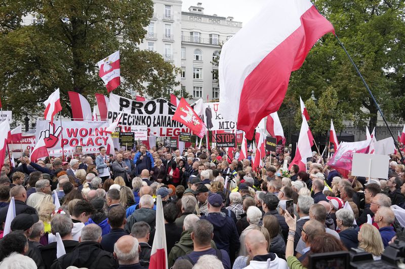 Backers of the right-wing opposition party Law and Justice take part in a protest ally of a few thousand people against the policies of Prime Minister Donald Tusk's Cabinet before the Ministry of Justice, in Warsaw, Poland, Saturday Sept. 14, 2024. (AP Photo/Czarek Sokolowski)