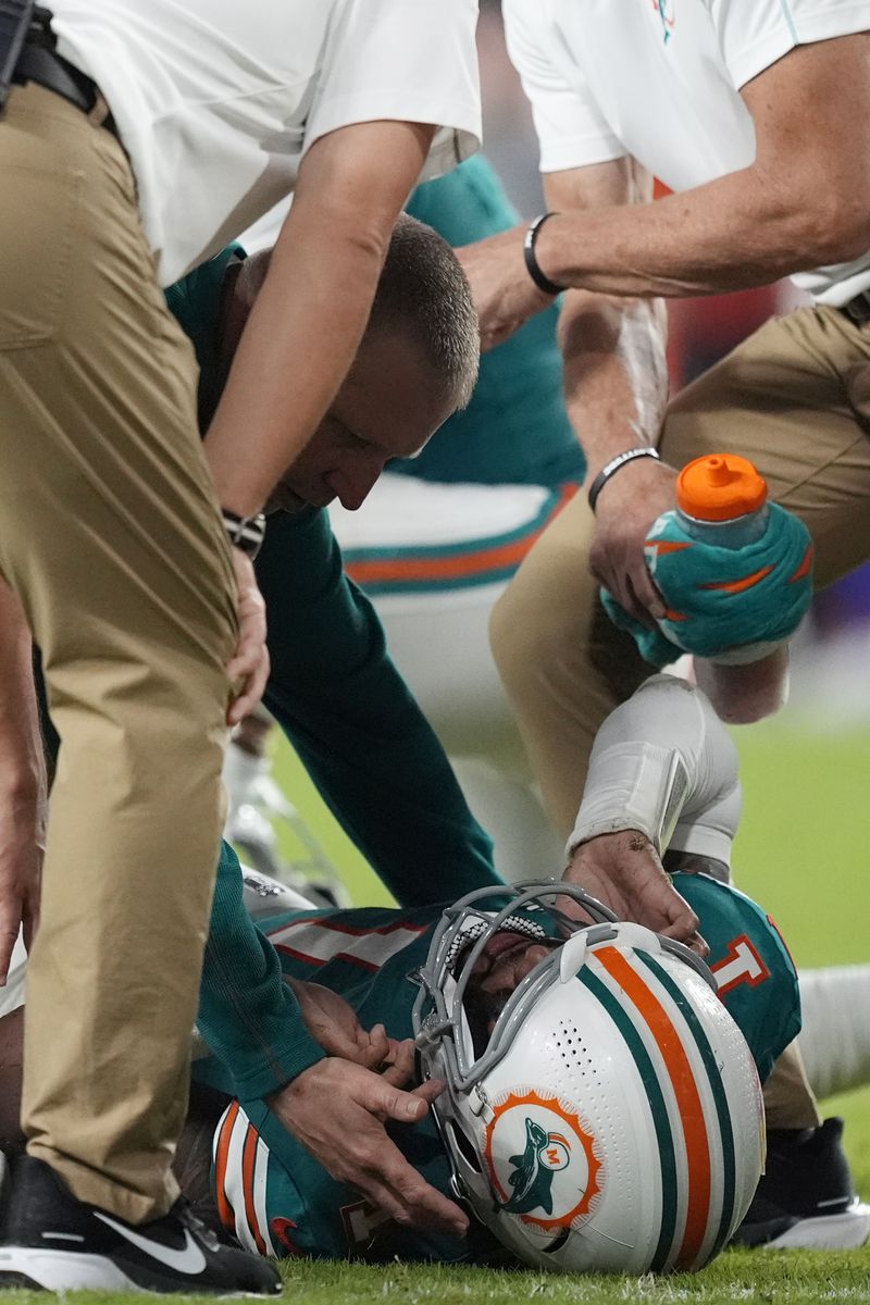 Miami Dolphins quarterback Tua Tagovailoa (1) is assisted on the field after suffering a concussion during the second half of an NFL football game against the Buffalo Bills, Thursday, Sept. 12, 2024, in Miami Gardens, Fla. (AP Photo/Rebecca Blackwell)