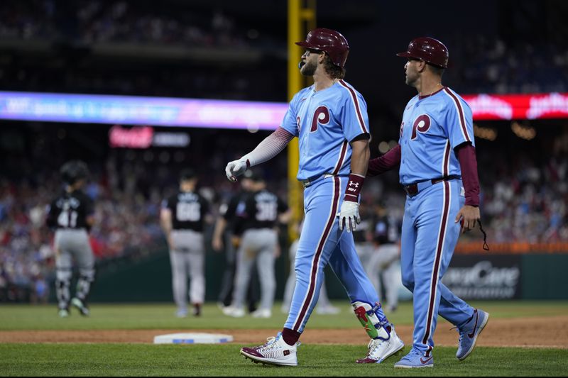 Philadelphia Phillies' Bryce Harper, left, walks off the field after grounding out against Miami Marlins pitcher Tanner Scott during the ninth inning of a baseball game, Thursday, June 27, 2024, in Philadelphia. (AP Photo/Matt Slocum)