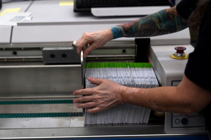 An election worker gathers vote-by-mail ballots for sorting during primary voting at the Multnomah County elections office on Tuesday, May 21, 2024, in Portland, Ore. (AP Photo/Jenny Kane)