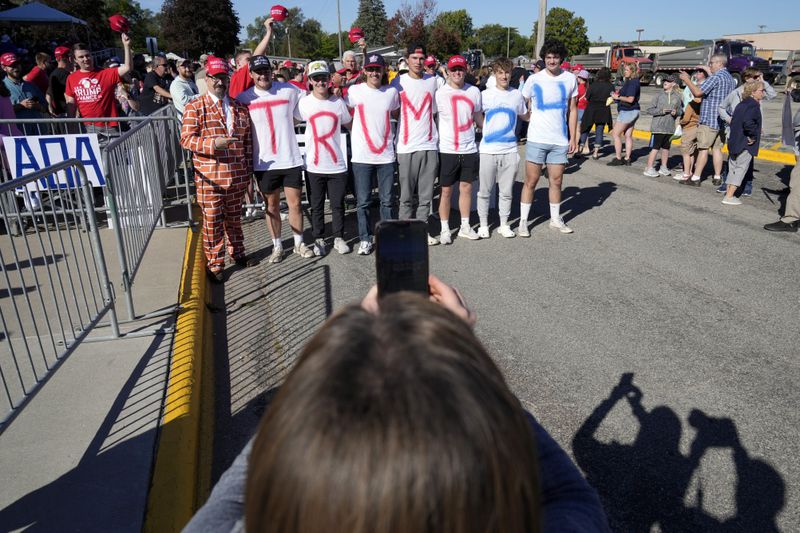 Supporters pose for a photo while waiting for Republican presidential nominee former President Donald Trump to arrive at a rally, Saturday, Sept. 28, 2024, in Prairie du Chien, Wis. (AP Photo/Charlie Neibergall)