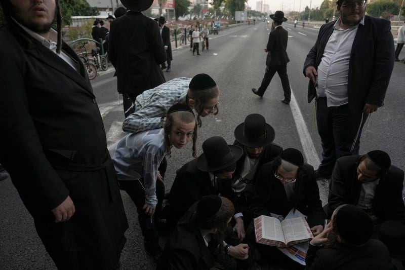 Ultra-Orthodox Jews block a highway during a protest against army recruitment in Bnei Brak, Israel, Thursday, June 27, 2024. Israel's Supreme Court unanimously ordered the government to begin drafting ultra-Orthodox Jewish men into the army — a landmark ruling seeking to end a system that has allowed them to avoid enlistment into compulsory military service. (AP Photo/Oded Balilty)