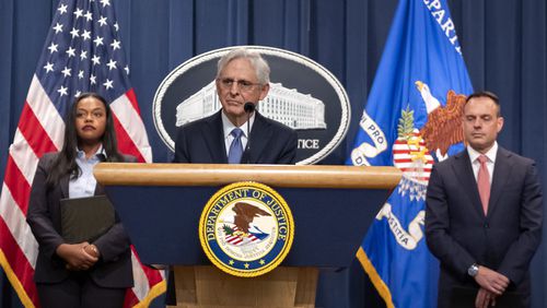 Attorney General Merrick Garland, center, is flanked by Principal Deputy Assistant Attorney General Doha Mekki, left, and Principal Deputy Associate Attorney General Benjamin Mizer, right, as he speaks during a news conference at the Department of Justice, Tuesday, Sept. 24, 2024, in Washington. (AP Photo/Mark Schiefelbein)