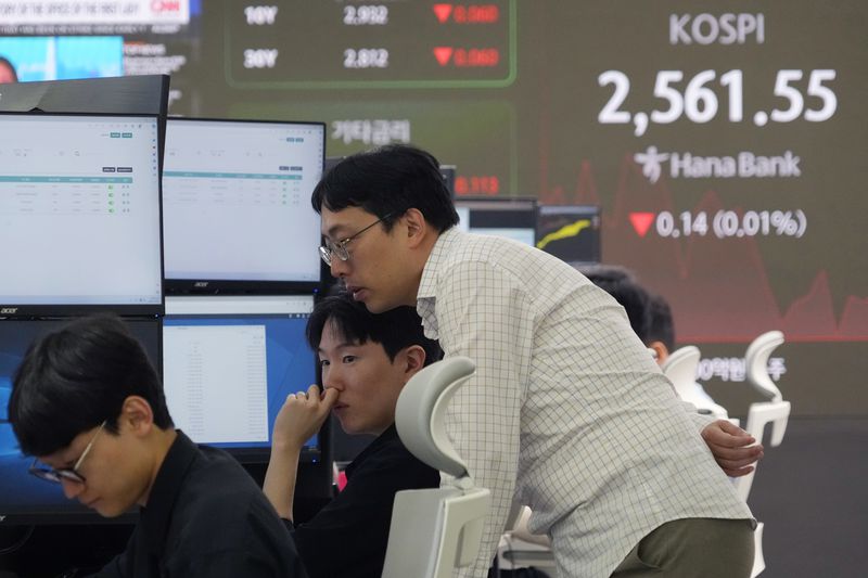 Currency traders watch monitors near a screen showing the Korea Composite Stock Price Index (KOSPI) at the foreign exchange dealing room of the KEB Hana Bank headquarters in Seoul, South Korea, Friday, Oct. 4, 2024. (AP Photo/Ahn Young-joon)