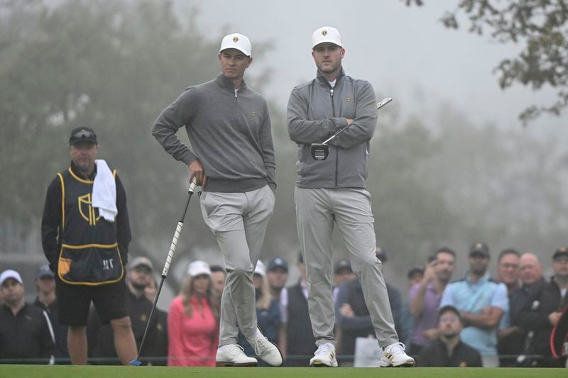 Adam Scott, left, of Australia, and Taylor Pendrith, of Canada, look on at the first green during third round four-ball play at the Presidents Cup golf tournament at Royal Montreal Golf Club, in Montreal, Saturday, Sept. 28, 2024. (Graham Hughes /The Canadian Press via AP)