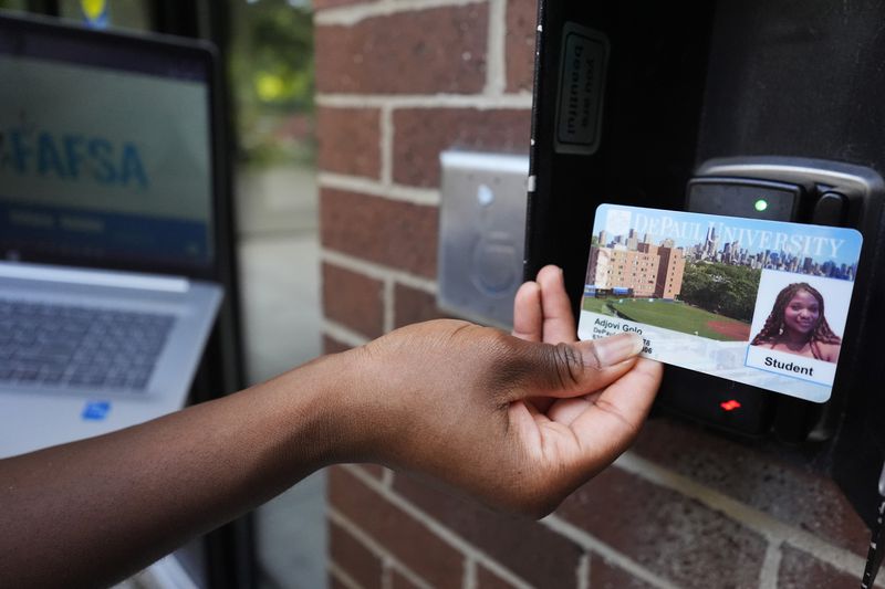 Adjovi Golo scans a school ID to enter a dormitory at DePaul University in Chicago, Wednesday, Aug. 28, 2024. (AP Photo/Nam Y. Huh)