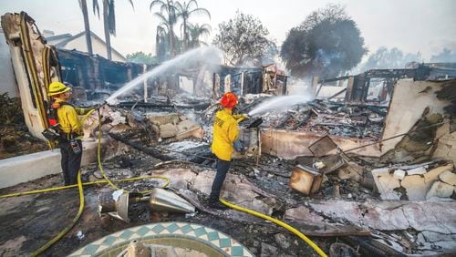 Firefighters hose down hot spots at Noel Piri's home that was destroyed by the Hawarden Fire in Riverside, Calif., on Sunday, July 21, 2024. (Terry Pierson/The Orange County Register via AP)