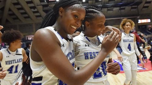 Westlake players Raven Johnson (25) and Ta’Niya Latson (20) walk off the court in celebration of their latest state title - a 64-46 victory over Carrollton - in the 6A girls championship game Friday, March 12, 2021, in Macon. (Hyosub Shin/hyosub.shin@ajc.com)