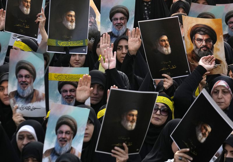 Mourners attend a rally commemorating slain Hezbollah leader Hassan Nasrallah and hold up his portraits, at Enqelab-e-Eslami (Islamic Revolution) St. in downtown Tehran, Iran, Monday, Sept. 30, 2024. (AP Photo/Vahid Salemi)