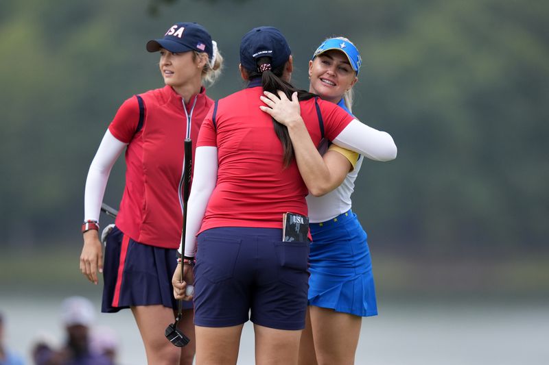 Europe's Charley Hull, right, congratulates United States' Allisen Corpuz, center, and Nelly Korda, left, on their win at the 16th hole during a Solheim Cup golf tournament foursomes match at Robert Trent Jones Golf Club, Friday, Sept. 13, 2024, in Gainesville, Va.(AP Photo/Chris Szagolo)