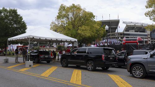 Automobiles are searched by law enforcement as they drive onto University Boulevard as Bryant-Denny Stadium is shown in the background, Saturday, Sept. 28, 2024, in Tuscaloosa, Al. Security was increased with the expected arrival of former President Donald Trump. (Jason Getz / AJC)

