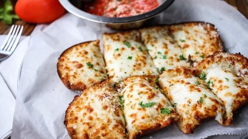 The cheesy garlic bread at Davinci's Pizzeria is loaded with cheese and fresh herbs, and comes with a side of house-made marinara. Courtesy of Davinci's Pizzeria