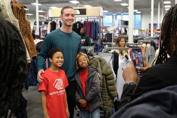 UGA quarterback Carson Beck poses with Boys and Girls club members Amir Bailey, 10 and Tymoen Blackwell, 9, while on a shopping spree at Academy. Carson Beck was on site at an Athens Academy store Sunday December 17, 2023, to give out gift cards to lucky members of area Boys and Girls Clubs. Academy contributed $200 for each child and he kicked in $135 more of his own money to help families out. 
credit: Nell Carroll for the AJC