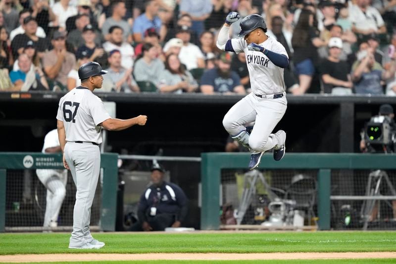 New York Yankees' Juan Soto, right, celebrates his home run off Chicago White Sox starting pitcher Jonathan Cannon with third base coach Luis Rojas during the fifth inning of a baseball game Tuesday, Aug. 13, 2024, in Chicago. (AP Photo/Charles Rex Arbogast)