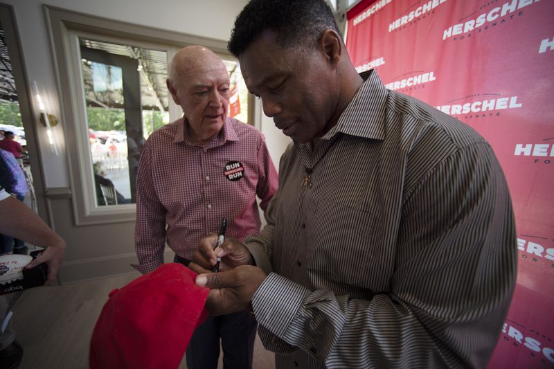 Republican Senate canididate Herschel Walker, signs an autograph after Walker spoke to supporters during a campaign stop, Saturday, May 14, 2022, in Ellijay, Ga. (AP Photo/Mike Stewart, Pool)
