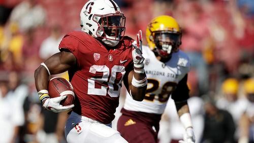 FILE - In this Sept. 30, 2017, file photo, Stanford running back Bryce Love, left, runs for a touchdown past Arizona State defensive back Demonte King (28) during the third quarter of an NCAA college football game in Stanford, Calif. Love established himself as a Heisman candidate early by rushing for 564 yards in back-to-back wins over UCLA and Arizona State. He kept adding to those numbers and leads all Power 5 running backs in yards rushing (1,973) yards per carry (8.3) and 100-yard games (11), and also set an FBS record with 12 runs of at least 50 yards. (AP Photo/Marcio Jose Sanchez, File)
