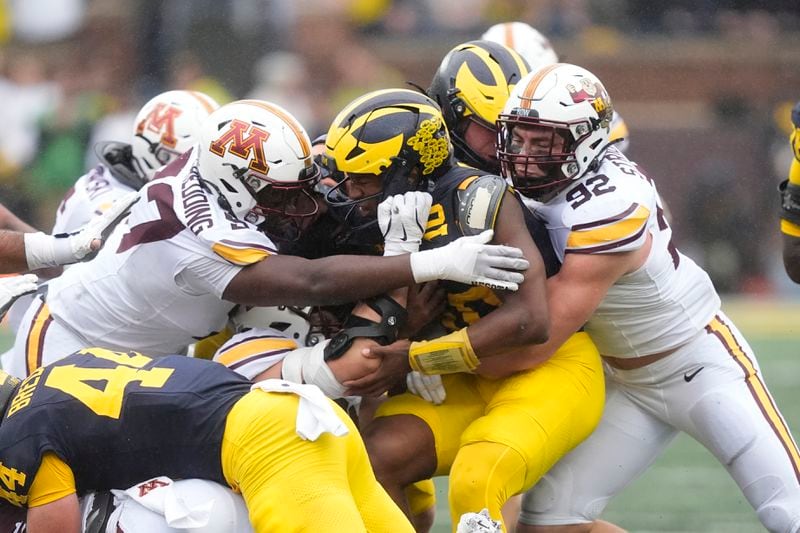 Michigan quarterback Alex Orji (10) is tackled during the first half of an NCAA college football game against Minnesota, Saturday, Sept. 28, 2024, in Ann Arbor, Mich. (AP Photo/Carlos Osorio)