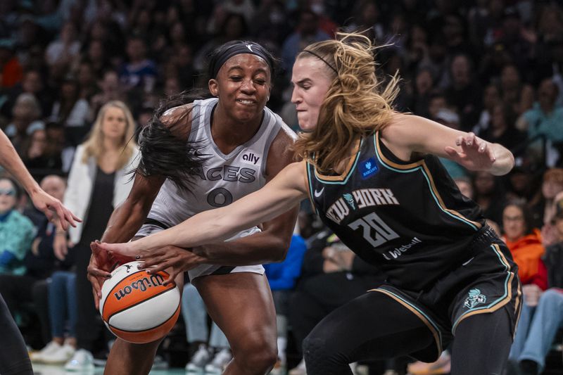 Las Vegas Aces guard Jackie Young (0) is defended by New York Liberty guard Sabrina Ionescu (20) during the second half of a WNBA basketball second-round playoff game, Sunday, Sept. 29, 2024, in New York. (AP Photo/Corey Sipkin)