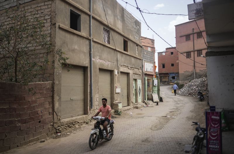 A man drives past a building which was affected by the 2023 earthquake, in the town of Amizmiz, outside Marrakech, Morocco, Wednesday, Sept. 4, 2024. (AP Photo/Mosa'ab Elshamy)