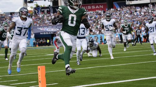 New York Jets running back Braelon Allen (0) runs the ball in for a touchdown against Tennessee Titans safety Amani Hooker (37) in the second half of an NFL football game in Nashville, Tenn., on Sunday, Sept. 15, 2024. (AP Photo/George Walker IV)