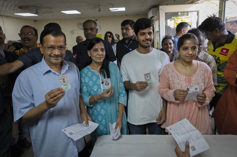 Aam Aadmi Party leader and Chief Minister of Delhi, Arvind Kejriwal, left, stands next to his family members as they show their identity cards at a polling booth before casting their vote in the sixth round of polling in India's national election in New Delhi, India, Saturday, May 25, 2024. (AP Photo/Altaf Qadri)