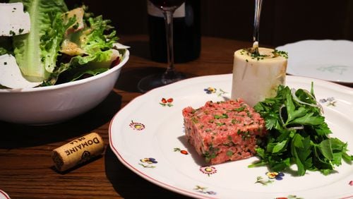 Among the hors d'oeuvres at Little Sparrow are the salade maison (left) and the filet Américain, served with bone marrow and parsley. Courtesy of Little Sparrow