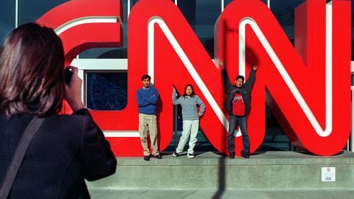 Visitors take a souvenir photo at the CNN sign outside CNN Center in 1999. (AJC File).