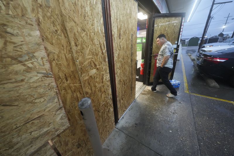 Oscar Torres, of Morgan City, enters a gas station that is boarded up in anticipation of Hurricane Francine, in Morgan City, La., Wednesday, Sept. 11, 2024. (AP Photo/Gerald Herbert)