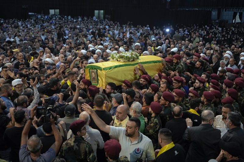 Hezbollah fighters carry the coffin of their comrade, senior commander Mohammad Naameh Nasser, who was killed by an Israeli airstrike that hit his car in the southern costal town of Tyre, during his funeral procession in the southern suburbs of Beirut, Lebanon, Thursday, July 4, 2024. (AP Photo/Bilal Hussein)