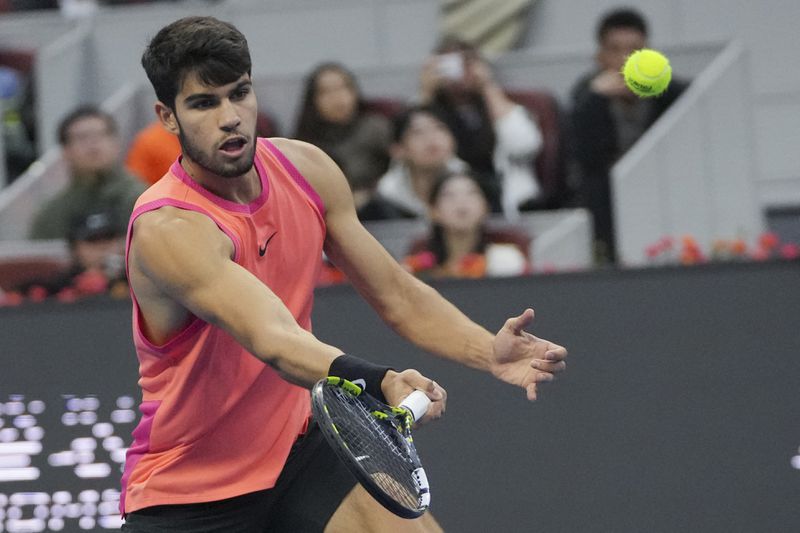 Carlos Alcaraz of Spain plays a forehand return against Jannik Sinner of Italy during their men's singles finals match of the China Open tennis tournament, at the National Tennis Center in Beijing, Wednesday, Oct. 2, 2024. (AP Photo/Achmad Ibrahim)