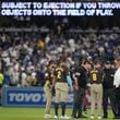 San Diego Padres manager Mike Shildt (8) and players talk to umpires after items were thrown on the field by fans during the seventh inning in Game 2 of a baseball NL Division Series against the Los Angeles Dodgers, Sunday, Oct. 6, 2024, in Los Angeles. (AP Photo/Ashley Landis)