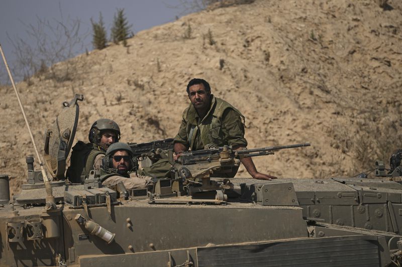 Israeli soldiers sit on their vehicle near the Israel-Gaza border in southern Israel, Friday, July 12, 2024. (AP Photo/Tsafrir Abayov)