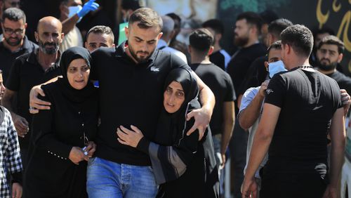 FILE - People react during the funeral procession of their relatives, who were killed in Monday's Israeli airstrikes, in the southern village of Saksakieh, Lebanon, Tuesday, Sept. 24, 2024. (AP Photo/Mohammed Zaatari, File)