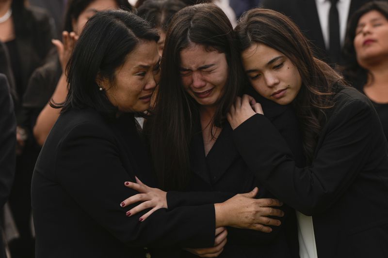 Keiko Fujimori, left, embraces her daughters Kiara, center, and Kaori during the funeral of her father, former President Alberto Fujimori, in Lima, Peru, Saturday, Sept. 14, 2024. (AP Photo/Guadalupe Pardo)