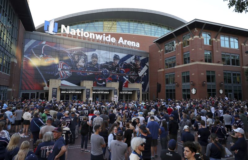 Fans gather for a candlelight vigil to honor Columbus Blue Jackets hockey player Johnny Gaudreau, outside of Nationwide Arena in Columbus, Ohio, Thursday, Sept. 4, 2024. Gaudreau and his brother Matthew were killed by a motor vehicle last week while riding bicycles. (AP Photo/Joe Maiorana)