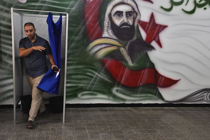 A voter prepares to cast his ballot inside a polling station during the presidential election, Tuesday, Aug. 27, 2024, in Algiers, Algeria. (AP Photo/Fateh Guidoum)