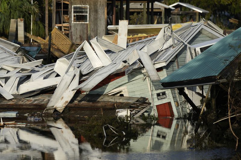 FILE - A home which came off its blocks sits partially submerged in a canal, in Horseshoe Beach, Fla., Friday, Sept. 1, 2023, two days after the passage of Hurricane Idalia. Nearly all the experts think 2024 will be one of the busiest Atlantic hurricane seasons on record. (AP Photo/Rebecca Blackwell, File)