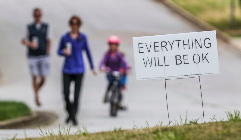 Left to right — Matt Blackburn, Shannon Blackburn, 4-year-old Jackson and 7-year-old Henley pass one of several “Everything Will Be OK” yard signs along Trailridge Lane in Dunwoody, where a nonprofit group called CREATE Dunwoody is raising money from sales of the yard signs to help provide much-needed funds for artists and art teachers affected financially during the pandemic. JOHN SPINK/JSPINK@AJC.COM