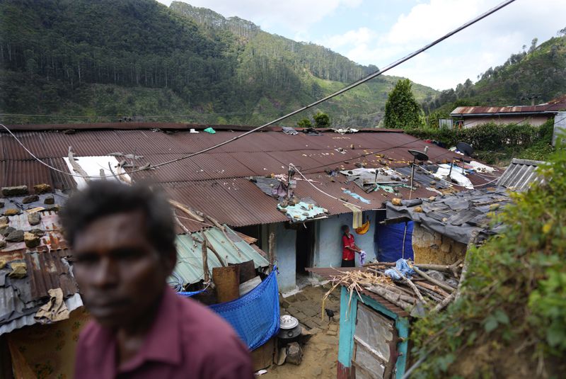 Tea plantation worker Muthuthewarkittan Manohari, far right, bathes her younger daughter Madubhashini outside their small living quarters in Spring Valley estate in Badulla, Sri Lanka, Monday, Sep. 9, 2024. (AP Photo/Eranga Jayawardena)