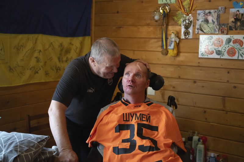 Serhii Shumei, 65, talks to his son Vitalii, 36, a Ukrainian officer heavily wounded in a battle with Russian forces, at the rehabilitation centre in Modrychi, Western Ukraine, Wednesday, Aug. 28, 2024. (AP Photo/Efrem Lukatsky)