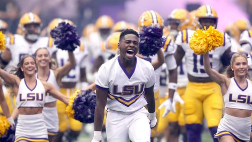 LSU cheerleaders lead players onto the field for an NCAA college football game against Southern California, Sunday, Sept. 1, 2024, in Las Vegas. (AP Photo/Steve Marcus)