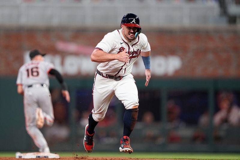 Atlanta Braves' Adam Duvall (14) runs away from second base after San Francisco Giants shortstop Nick Ahmed (16) makes an error in the sixth inning of a baseball game, Wednesday, July 3, 2024, in Atlanta. (AP Photo/Brynn Anderson)