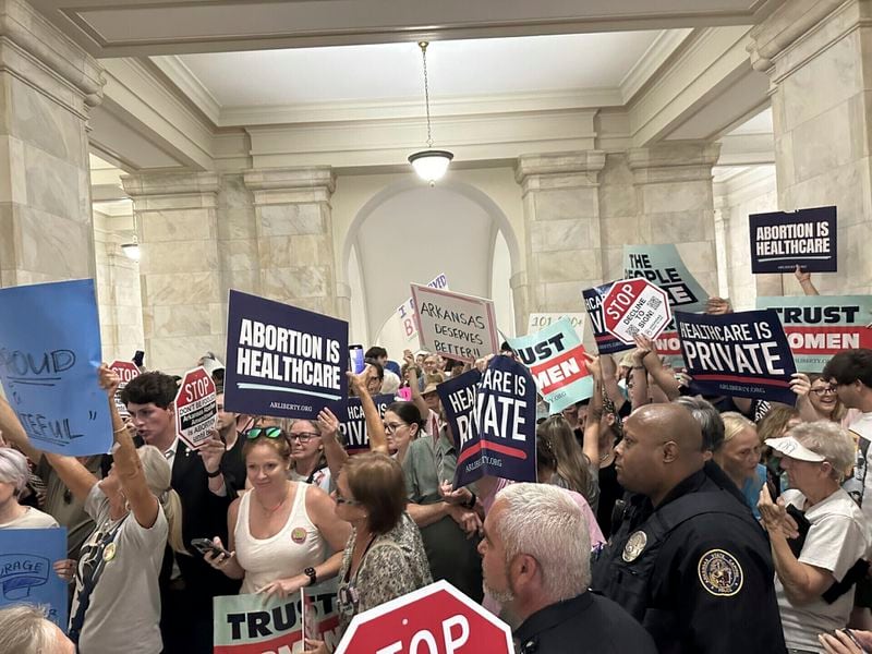 FILE - Supporters and opponents of a proposed ballot measure to scale back Arkansas' abortion ban hold signs outside the old Supreme Court chamber at the state Capitol in Little Rock, Ark., July 5, 2024. (AP Photo/Andrew DeMillo, file)