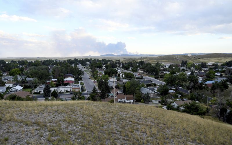 A wildfire burns behind the cityscape of Lusk, Wyo., on July 30, 2024. (AP Photo/Thomas Peipert)