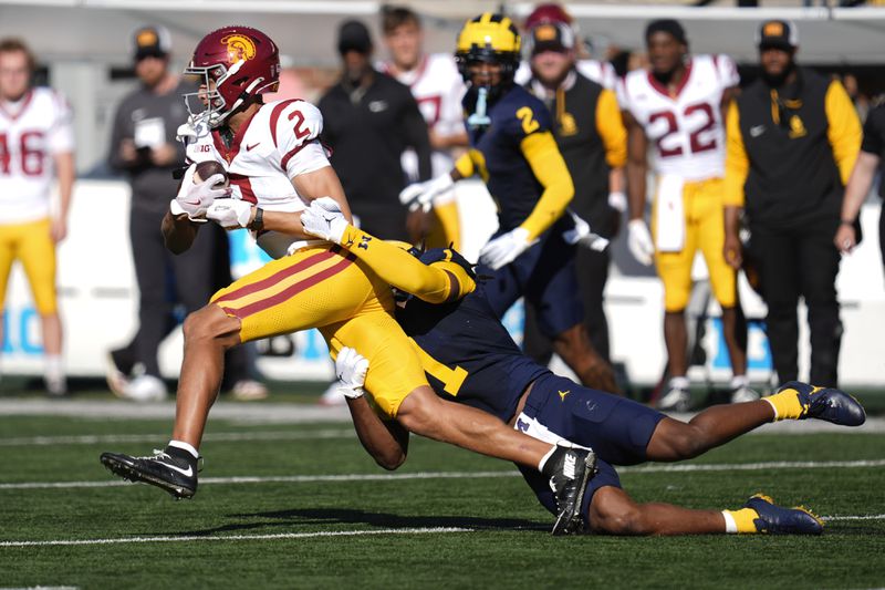 Southern California wide receiver Duce Robinson (2) is brought down by Michigan linebacker Jaishawn Barham (1) in the first half of an NCAA college football game in Ann Arbor, Mich., Saturday, Sept. 21, 2024. (AP Photo/Paul Sancya)