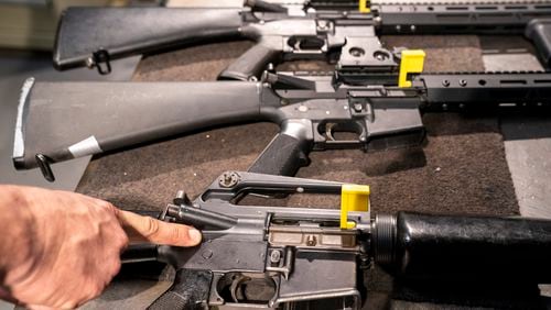 FILE - A finger points to a pin of an M-16 that makes it a fully automatic machine gun receiver, in a row of AR-15 style rifles at the Bureau of Alcohol, Tobacco, Firearms, and Explosives (ATF) National Services Center, March 2, 2023, in Martinsburg, W.Va. (AP Photo/Alex Brandon, File)