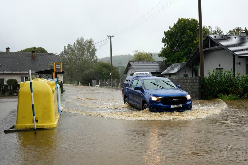 A car drives through a flooded street in Brantice, Czech Republic, Saturday, Sept. 14, 2024. (AP Photo/Petr David Josek)