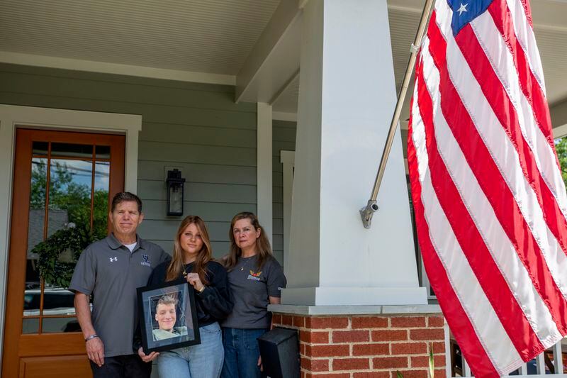 Family members of Marine Corporal Spencer R. Collart, from left, father Bart Collart, sister Gwyneth Collart and mother Alexia Collart, hold his portrait as they pose for a photo at their home in Arlington, Va., Thursday, June 19, 2024. Collart, 21, was killed along with two other Marines when the MV-22B Osprey aircraft they were on crashed during drills on a north Australian island on August 27, 2023. (AP Photo/Rod Lamkey, Jr.)