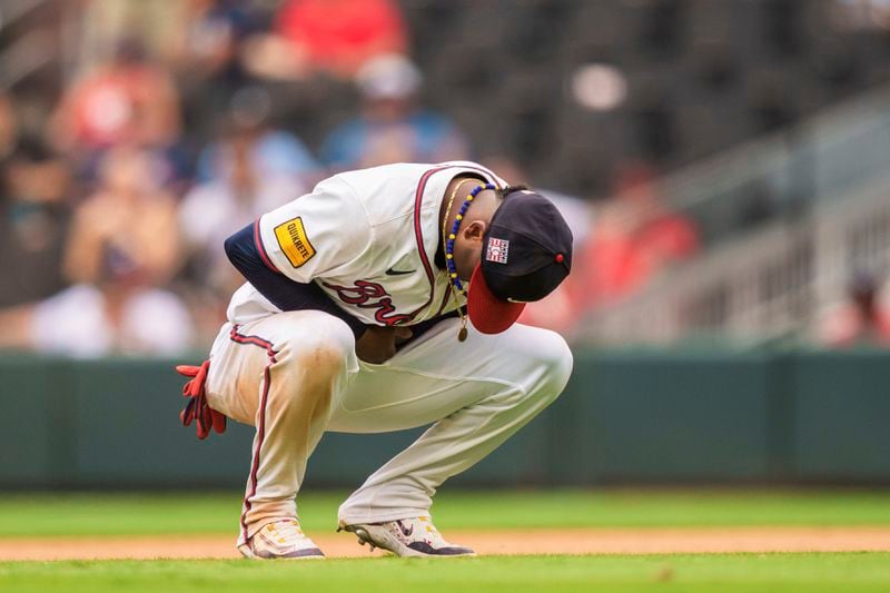 FILE - Atlanta Braves second baseman Ozzie Albies holds his wrist after an injury in the ninth inning of a baseball game against the St. Louis Cardinals, Sunday, July 21, 2024, in Atlanta. (AP Photo/Jason Allen, File)